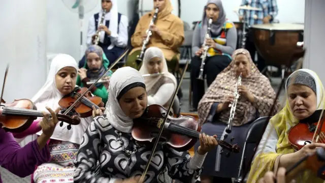 Egyptian women practise their violins and oboes in the orchestra room