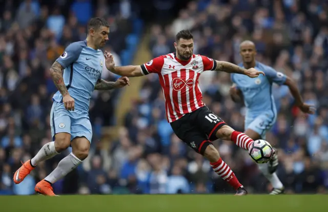 Charlie Austin in action with Manchester City's Aleksandar Kolarov