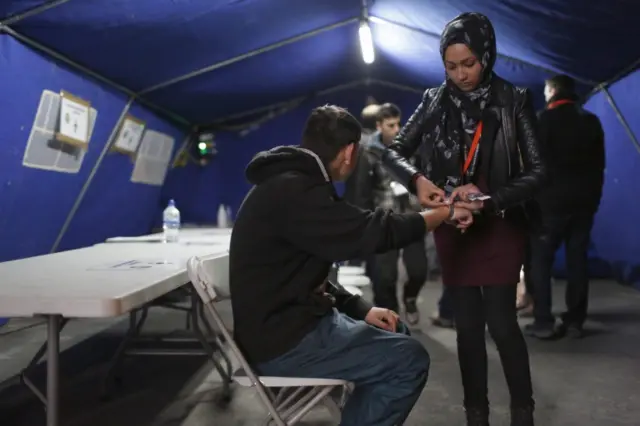 A migrant getting a wristband