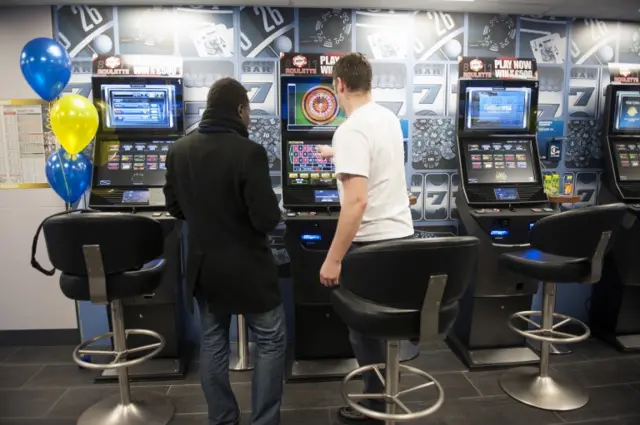 Men gambling on fixed odds betting machines