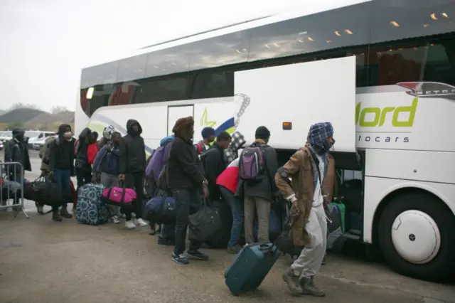 Migrants queuing for a coach