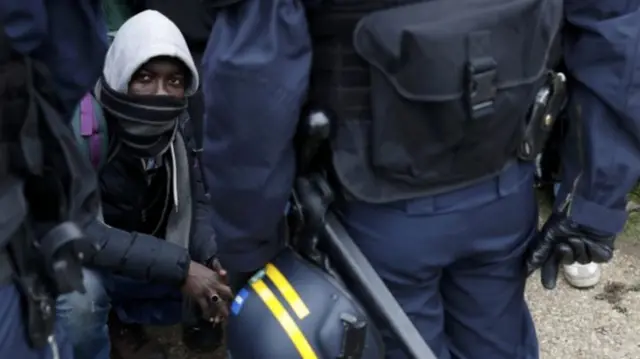 A migrant prepares to leave the Jungle camp