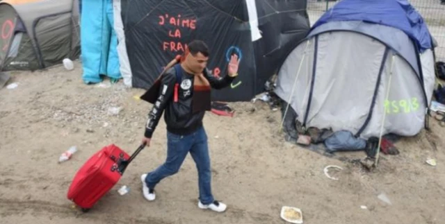 A migrant walks through the Jungle camp in Calais