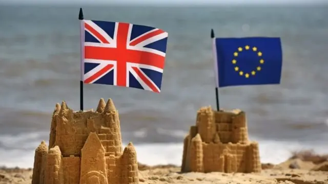 sandcastles with British and EU flags