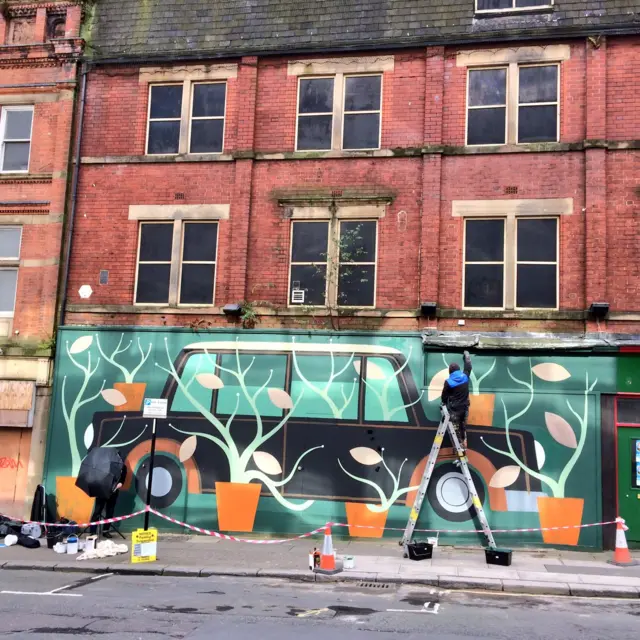 Scene of car and trees being painted on wall