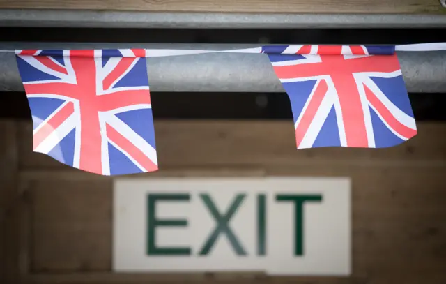 Union jack bunting flying above an exit sign