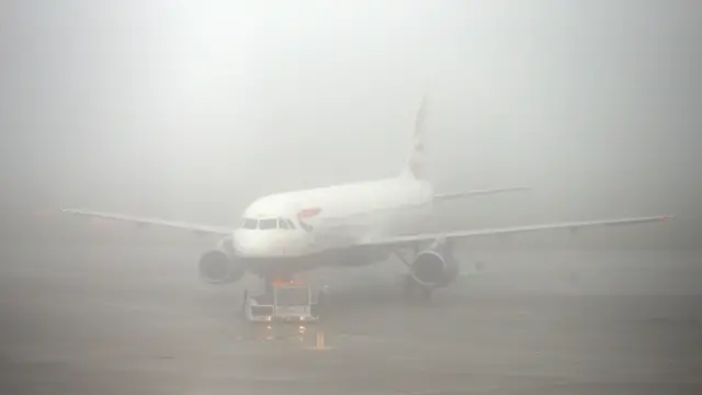 A plane sits in fog at Heathrow