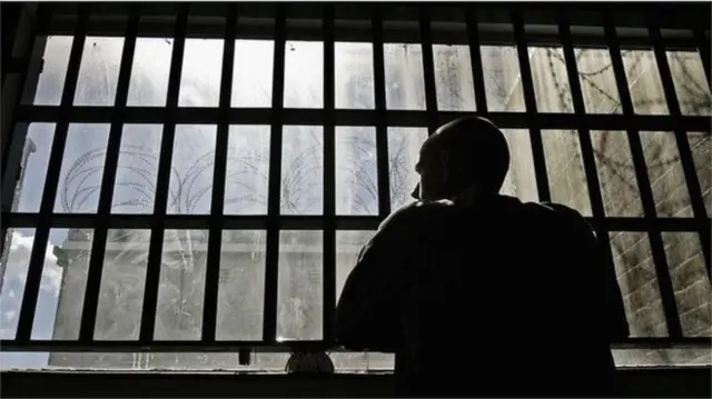 man looking out of prison window