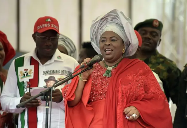 Nigerian President and presidential candidate of the ruling People's Democratic Party (PDP) Goodluck Jonathan (L) looks at notes as his wife Patience addresses an election rally in Port Harcourt, in the Niger Delta region, on January 28, 2015.