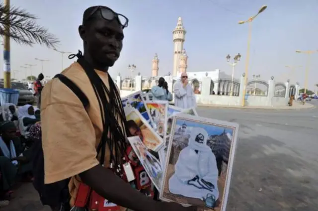 A street vendor sells images of local Mourides religious leaders, including the founder of the brotherhood Cheikh Ahmadou Bamba Macke, near the grand mosque in Touba