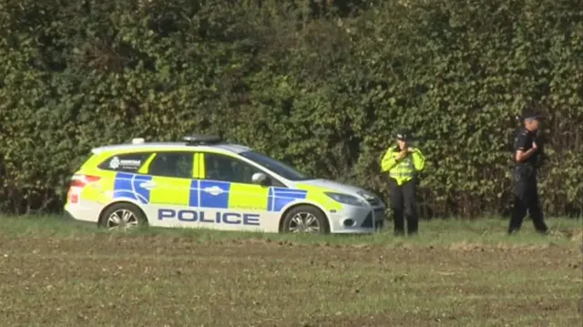 A police car, and police officers