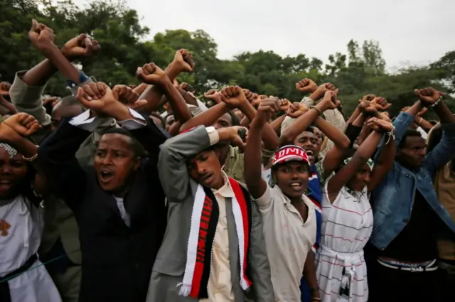 People with their arms held above their heads