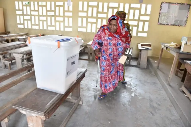 A woman arrives to cast her ballot at a polling station in the popular district of Yopougon in Abidjan, on October 30, 2016, during a referendum on a revised constitution