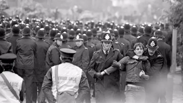 Police officers restrain an activist on the picket line, Orgreave Coking Plant, Rotherham. June 1984.