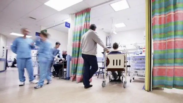 Doctors and patients in an NHS hospital department