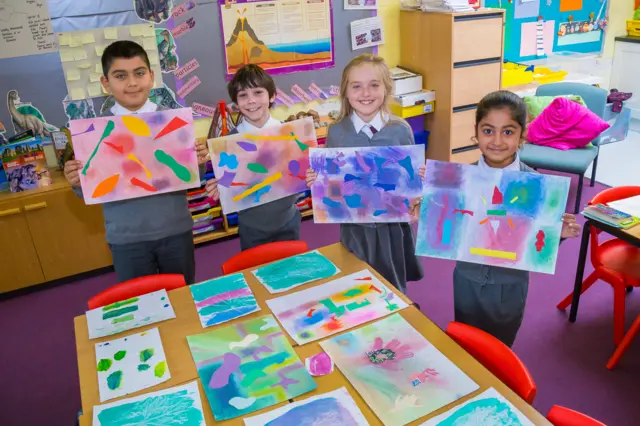 Children holding up art work