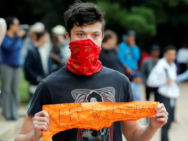 A student opposing a protest over high tuition fees holds a placard at Johannesburg"s University of the Witwatersrand, South Africa, October 4,2016