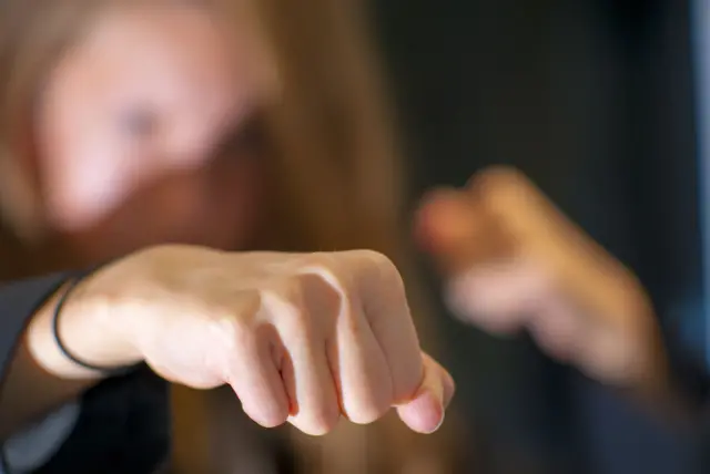 A blurred image of a young girl holding out a clenched fist