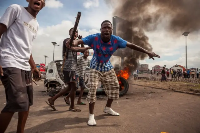 This file photo taken on September 19, 2016 shows demonstrators gathering in front of a burning car during an opposition rally in Kinshasa