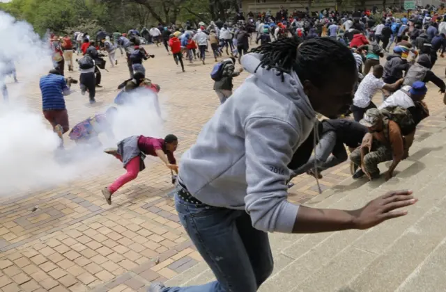 Students from Wits University are thrown to the ground after a stun grenade exploded near them during running battles on the campus as ongoing protests continue against the cost of higher education in Johannesburg, South Africa, 04 October 2016