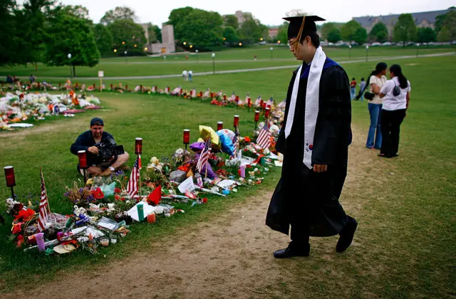 A graduate passes the makeshift memorial