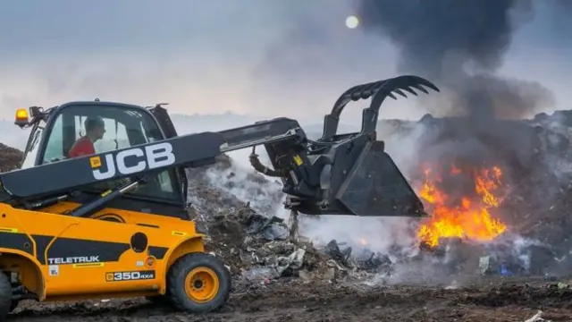 A JCB working at the site of the fire