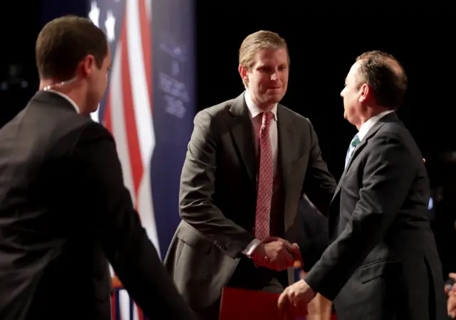 Eric Trump, son of Republican presidential nominee Donald Trump (C), shakes hands with Reince Priebus, chairman of the Republican National Committee