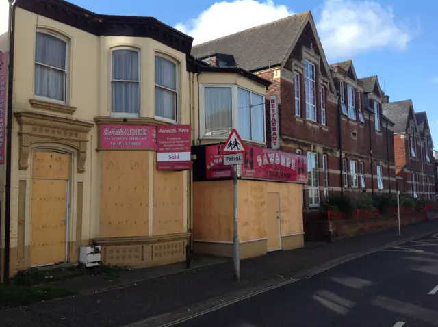 The boarded-up former restaurant next to the school