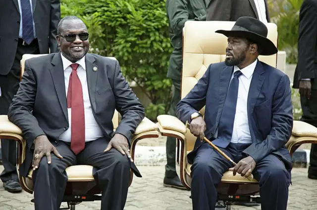 Riek Machar (left) sitting with Salva Kiir (right)