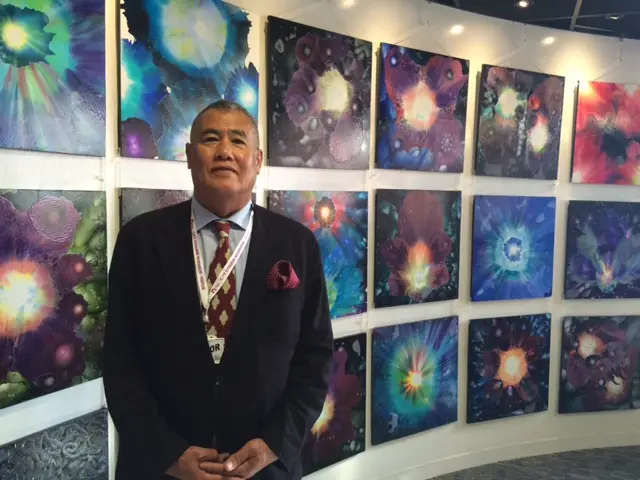 Danny Keen standing in front of art work