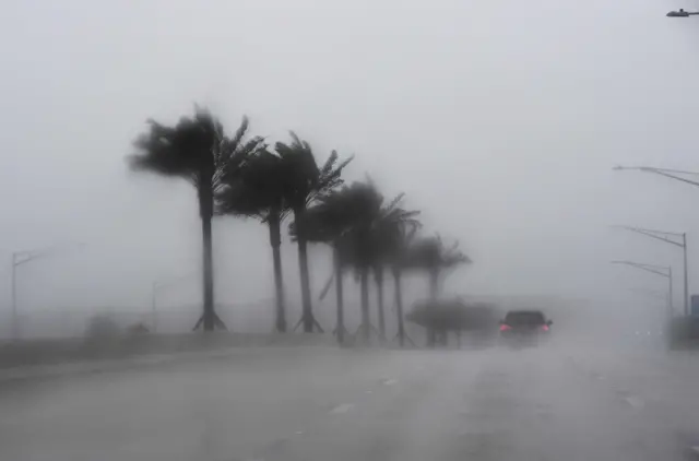 Commuters make their way through heavy rain in Jacksonville, Florida, on October 6, 2016, ahead of hurricane Matthew