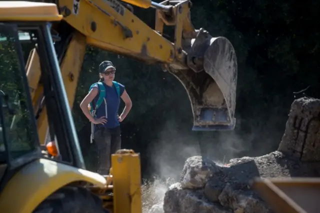 South Yorkshire Police officer watches as concrete rubble is removed at Kos search site