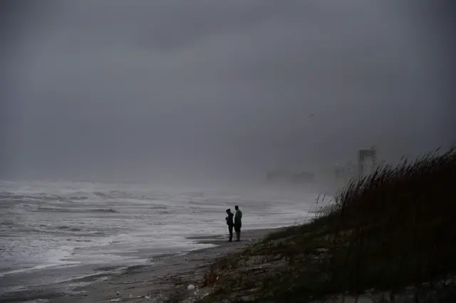 Local residents watch waves at the Atlantic Beach in Jacksonville, Florida, on October 6, 2016