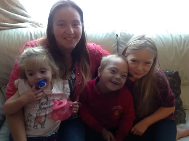 Crystal Long sitting with her two daughters, who are either side of Kian