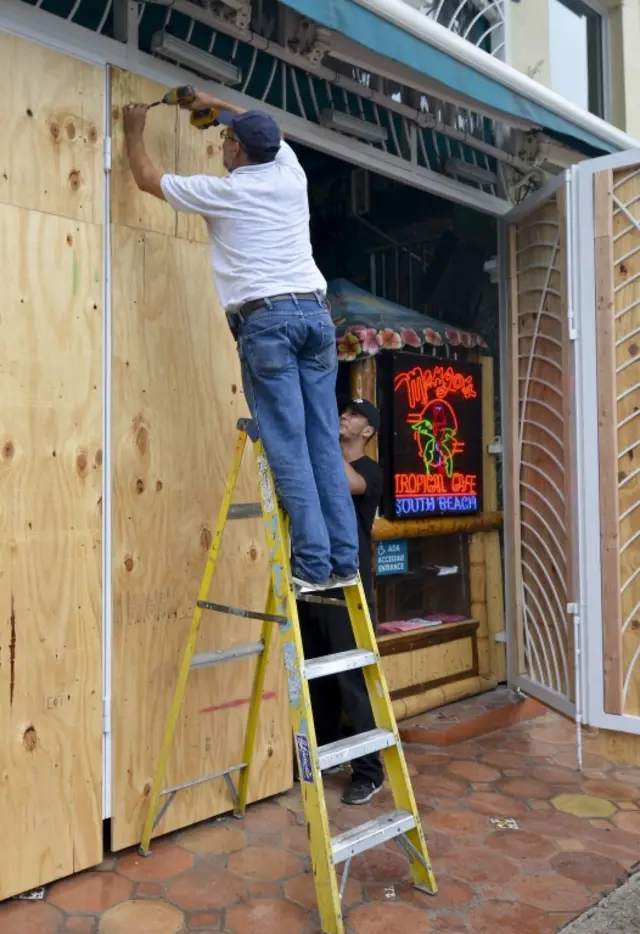 A maintenance worker boards up a property on Miami Beach, Florida