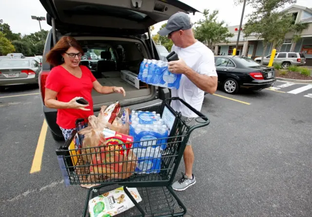 Laura and George Callahan of James Island, South Carolina, load up their vehicle with bottled water and food purchased ahead of the arrival of Hurricane Matthew, in Folly Beach, South Carolina