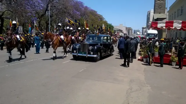 Rolls Royce flanked by guards on horseback