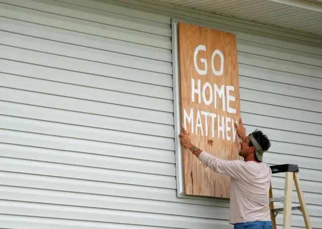 Homeowner Don Appell board ups his windows in South Carolina