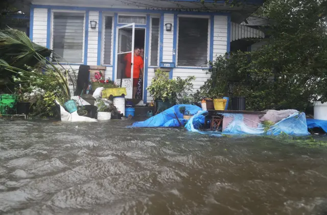 People look out at the flooded street in front of their home as Hurricane Matthew passes through the area in St Augustine, Florida