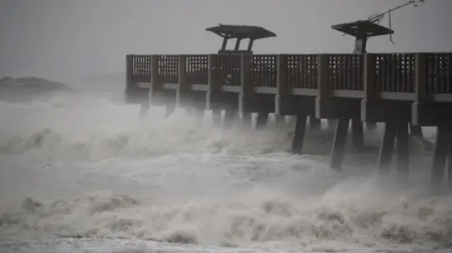 Huge waves pound a pier in Jacksonville, Florida