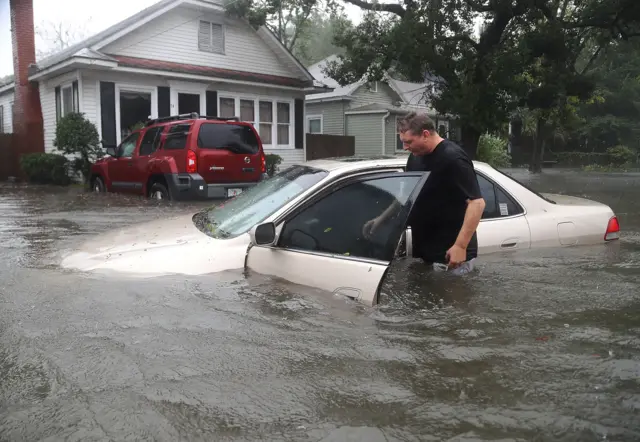 Rob Birch checks on his car which floated out of his drive way as Hurricane Matthew passes through the area in St Augustine, Florida.