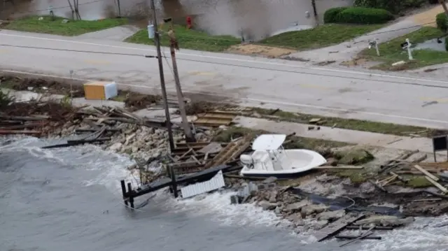 A boat washed ashore amid storm debris in Melbourne, Florida