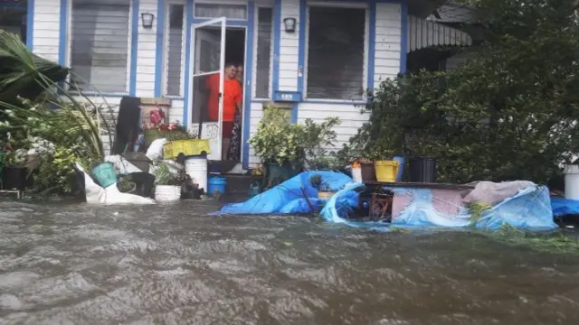 People look at a flooded street from their house in St Augustine, Florida