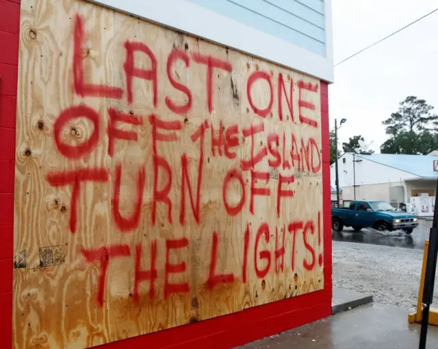 A car passes a sign posted as people evacuate from Tybee Island, Georgia