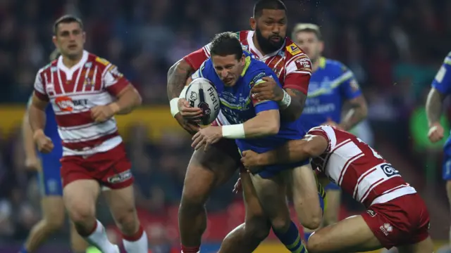 Kurt Gidley of Warrington is held up by Frank-Paul Nuuausala