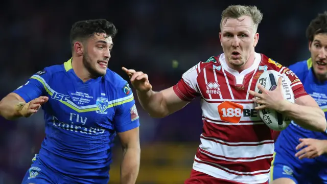 Dan Sarginson of Wigan Warriors is tackled by Declan Patton of Warrington Wolves