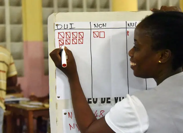 A woman takes score of votes at a polling station in Ivory Coast