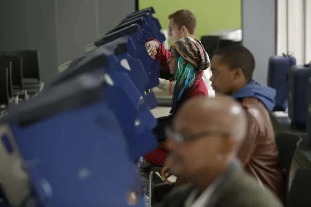 Voters cast their ballot during early voting at a polling station at Truman College in Chicago, Illinois.