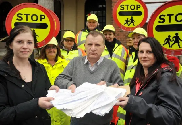 Cllr Pete Lowe receives the 8,890 signature petition from Laura Msyk and Kelly Round, alongside crossing patrol staff Jean Nicholls, Jill Curtis, Sue Cole, Julie Paskin and Sue Bradley.