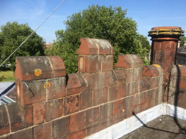 Crenelated red brickwork at the top of the tower